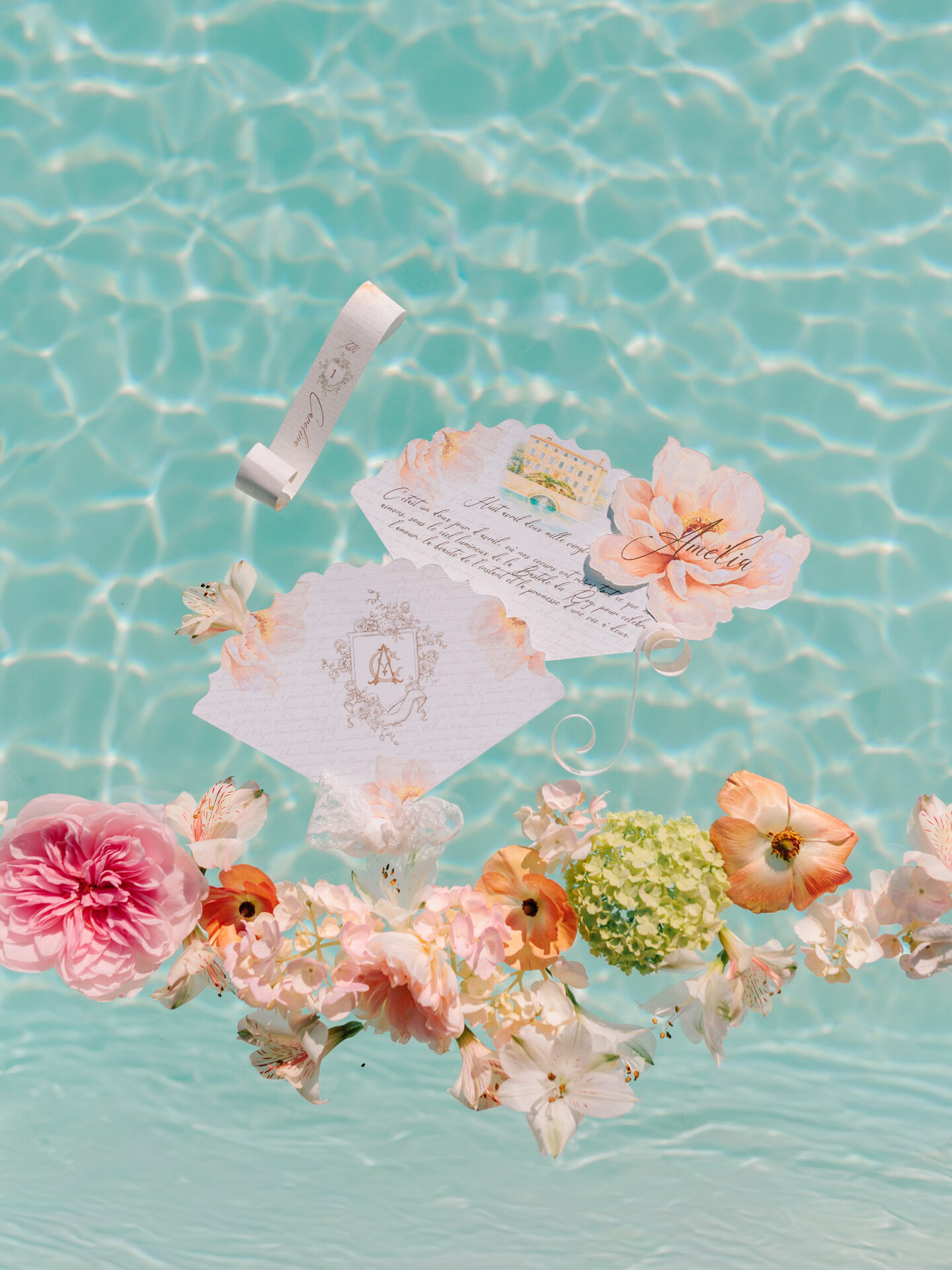 Faire-part et fleurs en flatlay flottant sur l'eau