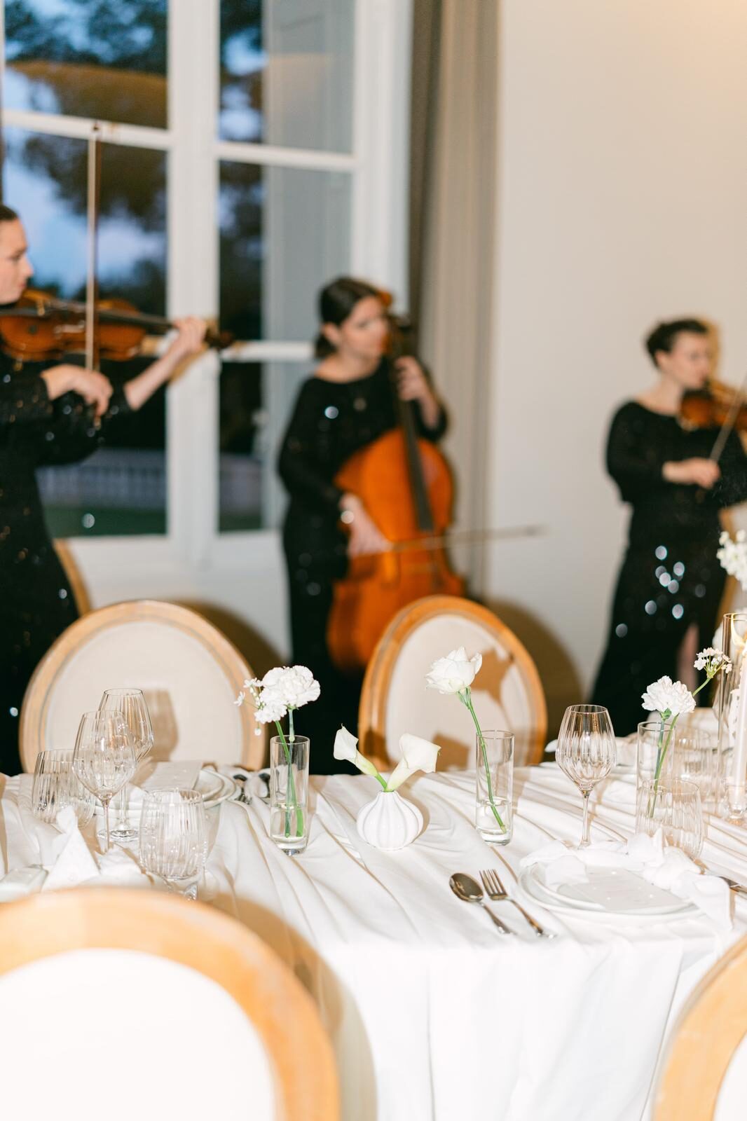 Trio à cordes jouant devant une table de réception dressée